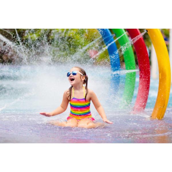 Los niños del círculo del arco iris del parque del espray de agua riegan el parque colorido del chapoteo del agua del patio