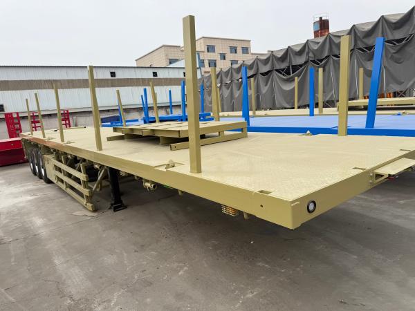 Semi-remorque à plateau à colonnes latérales pour le transport de bobines de bois et de conteneurs en acier