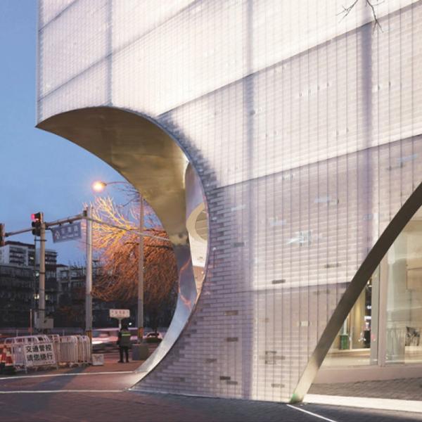 Diseño de Fachadas Comerciales: Cortinas de Bloques de Vidrio, un Muro de Día y una Pintura de Luz Urbana de Noche