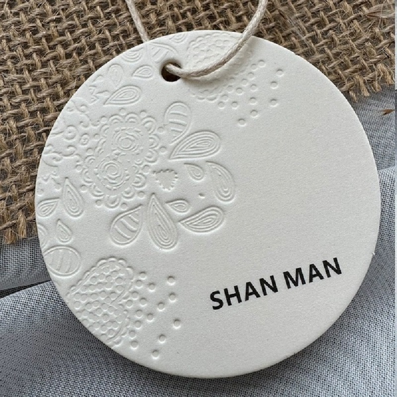 Embossed Round Paper Hang Tags With Relief Floral Pattern For Apparel Branding