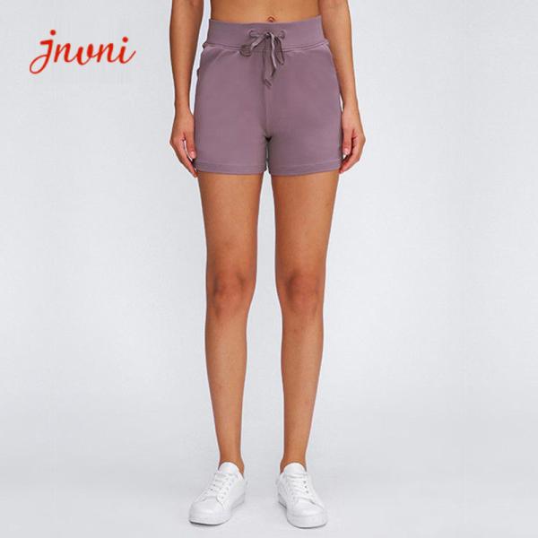 Os esportes das senhoras afrouxam o short do Gym com o short seco rápido da ioga do exercício dos bolsos