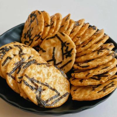 Os petiscos japoneses dos biscoitos quentes da alga da venda em volta do arroz endurecem o petisco torrado da grão dos biscoitos do arroz