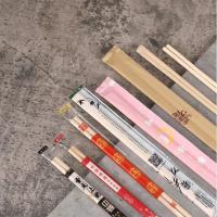 O papel de bambu gêmeo redondo japonês dos hashis do sushi cobriu descartável