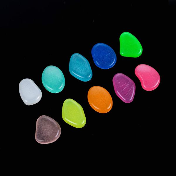 Resplandor plástico de la resina en el luminoso oscuro de los guijarros machacado