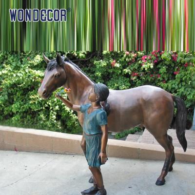 Vida feita sob encomenda - estátua de bronze do tamanho A de uma menina que joga com seu amigo do cavalo