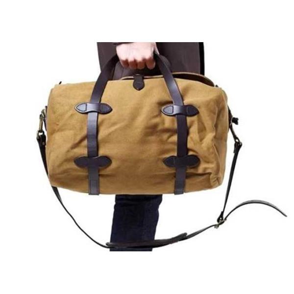 Свертывая вещевые мешки перемещения холста