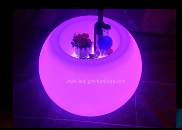 A bola dada forma conduzida ilumina acima a mesa de centro com cubeta de gelo e suporte de garrafa do vinho