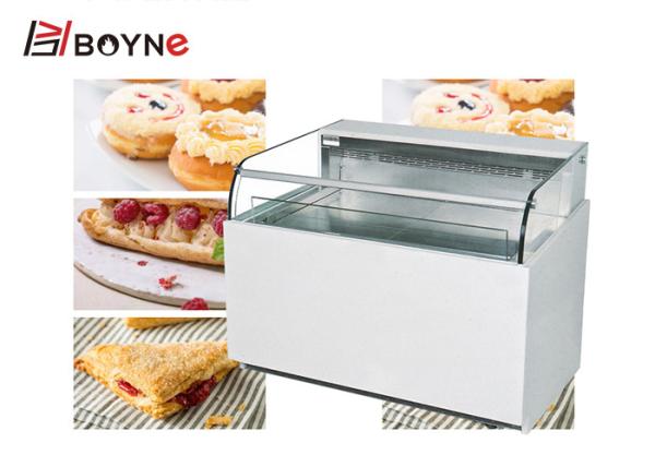 Um único refrigerador aberto lado da exposição do bolo de camada para o restaurante