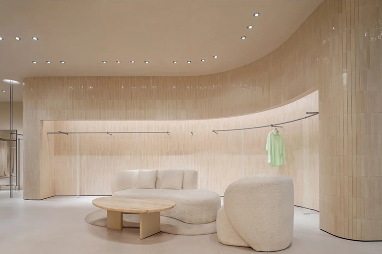 Wabi Sabi Minimalist Women Clothing Store Interior Design with Natural Travertine Curved Wall and Multi-functional Zoning Layout