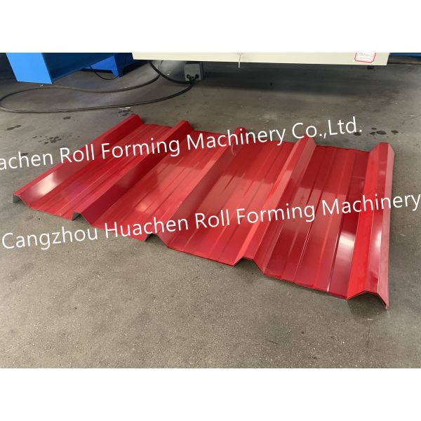 A metal roof panel manufacturing machine for producing tile-shaped corrugated roof panels by rolling process