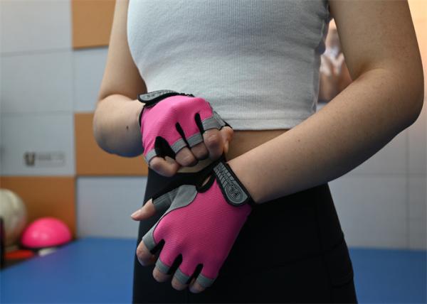 Luvas de treino de meio dedo cor-de-rosa e leves oferecem conforto e aderência durante as sessões de levantamento de peso.
