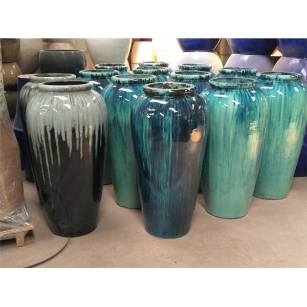 Круглый застекленный бак зеленого растения цветка голубой керамический на открытом воздухе