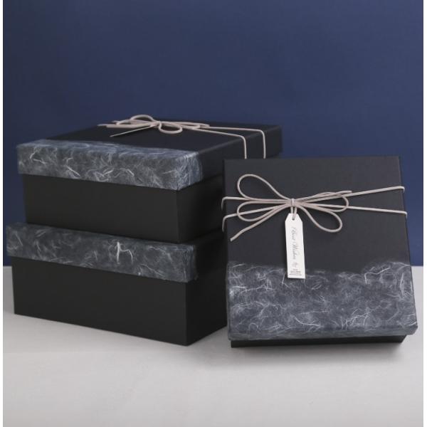 Las cajas de regalo de la Navidad del paquete plano reciclaron los materiales blancos de la cartulina con la cinta