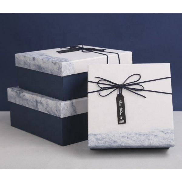 Las cajas de regalo de la Navidad del paquete plano reciclaron los materiales blancos de la cartulina con la cinta