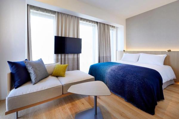 Perth hotel interior design FFE solution by laminate wood headboard bed with light luxury sofa and coffee table