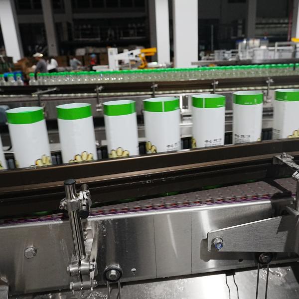 La cinquième génération d'applicateurs à manches rétrécissantes entièrement automatiques personnalisés pour 30000 BPH La ligne de production de boissons est testée en atelier